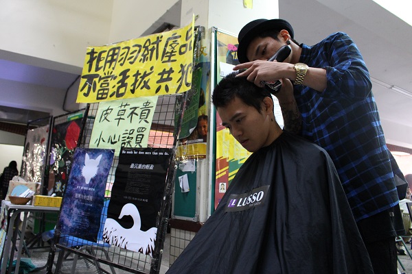 師大動陣成員朱信璁在宣導活動現場剃髮。　李娉婷/攝