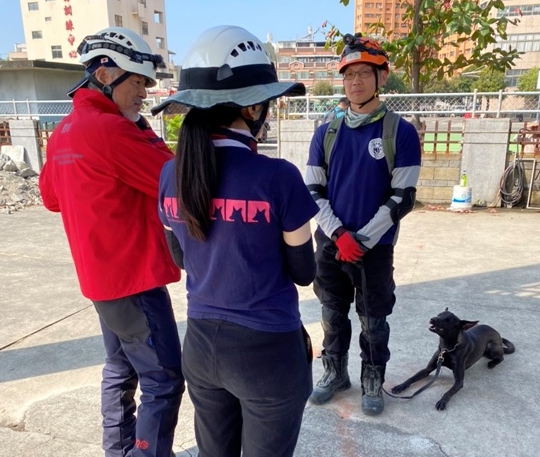 原為收容所浪犬的「黑糖」近日在領犬員李信宏的帶領下成功通過搜救犬瓦礫初級認證。 高雄市消防局/提供