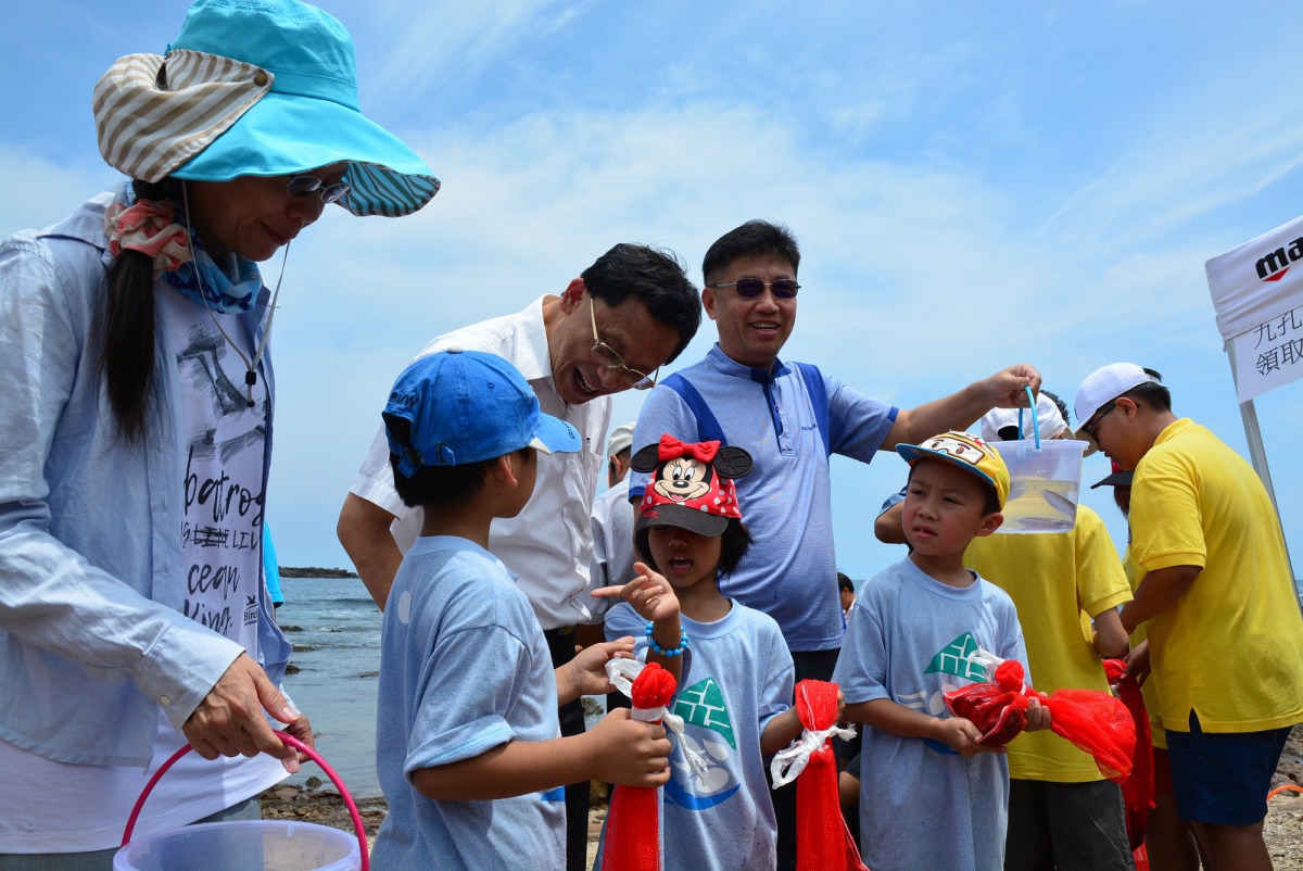 國小的孩童體驗放流九孔。 新北市漁業處/提供