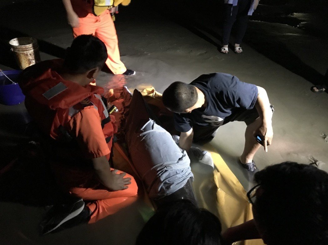 海巡人員與中華鯨豚協會徹夜照顧擱淺的糙齒海豚。海巡署中部分署第三岸巡隊/提供