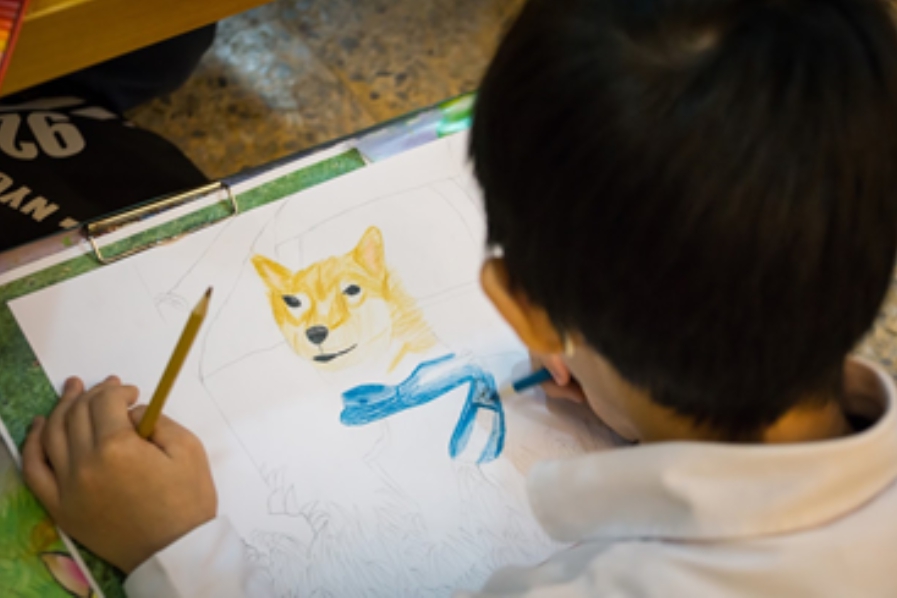 中和區秀山國小學生在美術課上描繪校園犬「好客」。 新北市動保處/提供