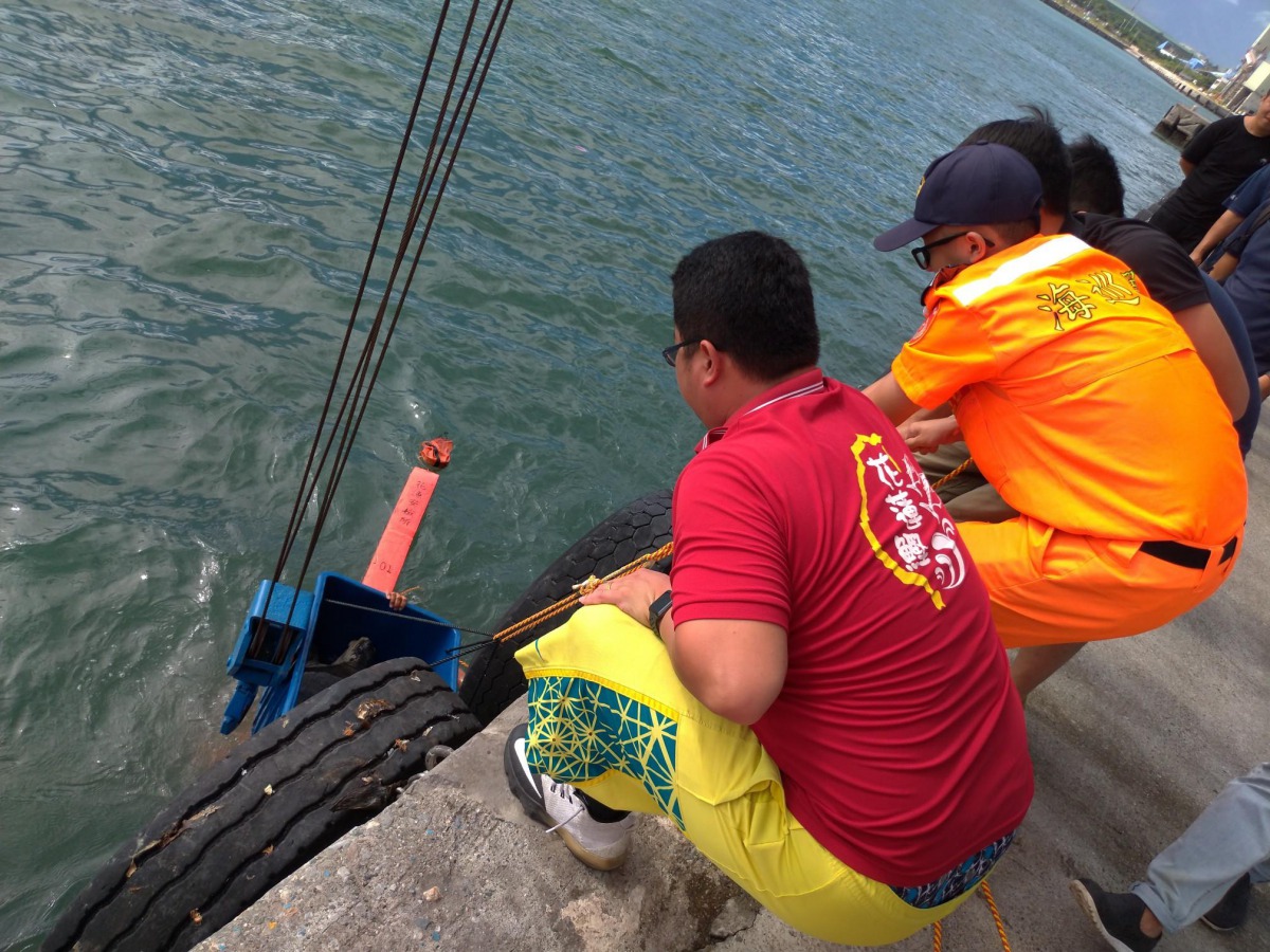 海巡人員將迷航的欖蠵龜打撈上岸。第一二岸巡隊/提供