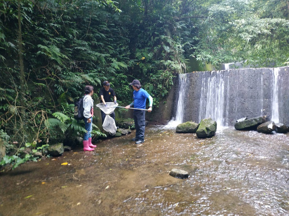 動保員和飼主在小水壩救援「小黑」。 新北市動保處/提供