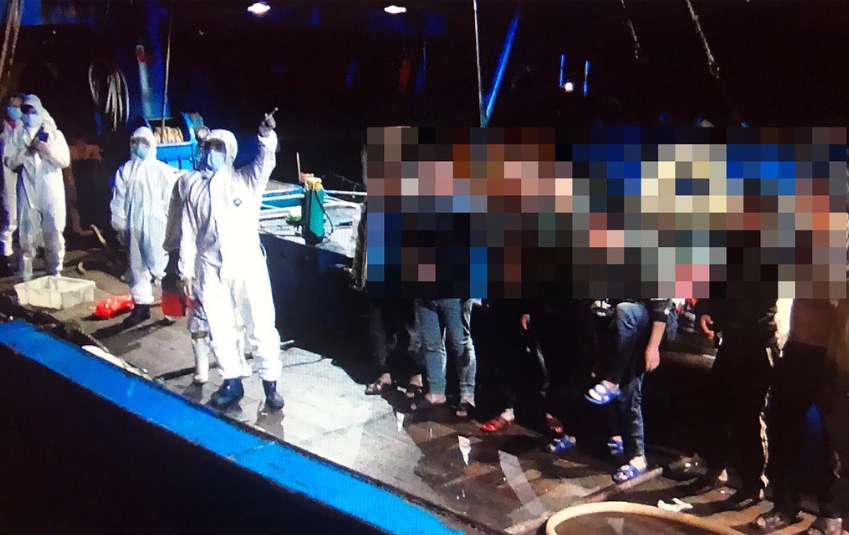 防疫人員全副武裝登船進行消毒作業。台中海巡隊/提供