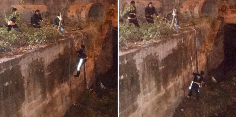 志工利用繩索垂降到大排水溝，救援受困的柯基。 邵柏虎/提供