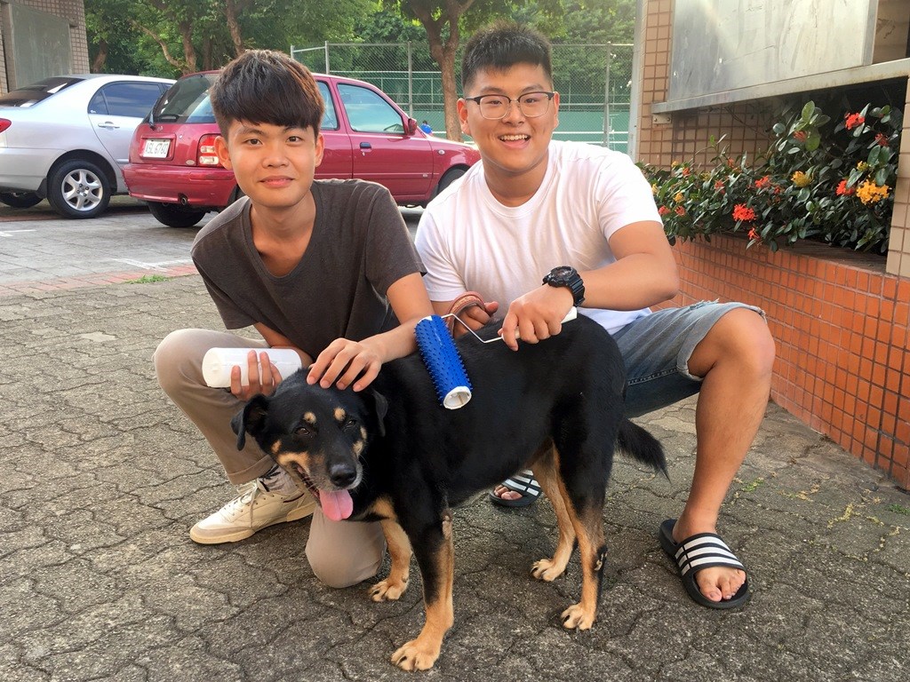 杜兆翔同學(右)為狗狗設計「滾輪毛梳」，兼具按摩與除毛功能。 中原大學/提供