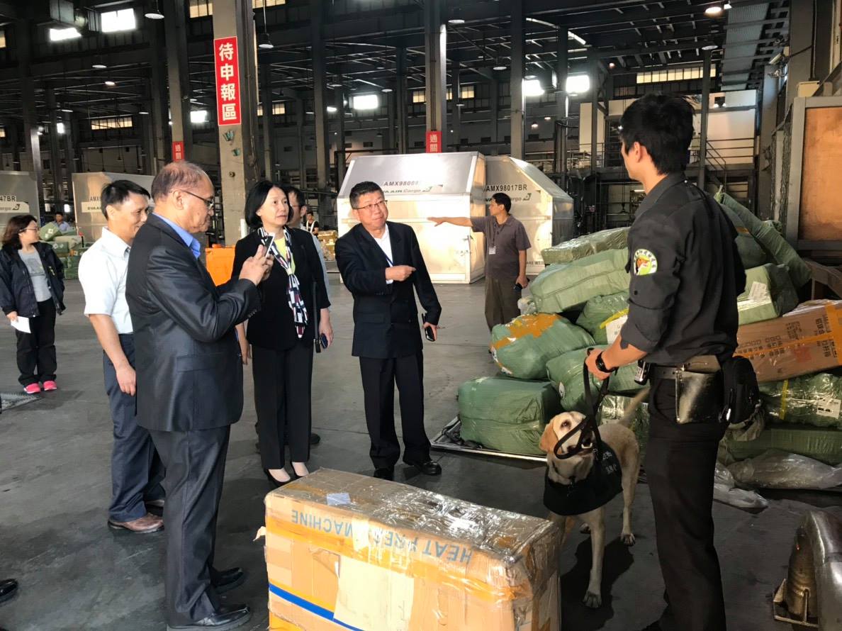 農委會許桂森參事及防檢局杜文珍副局長至桃園機場貨運倉儲視察檢疫人員與檢疫犬執行快遞包裹檢疫作業。 防檢局/提供