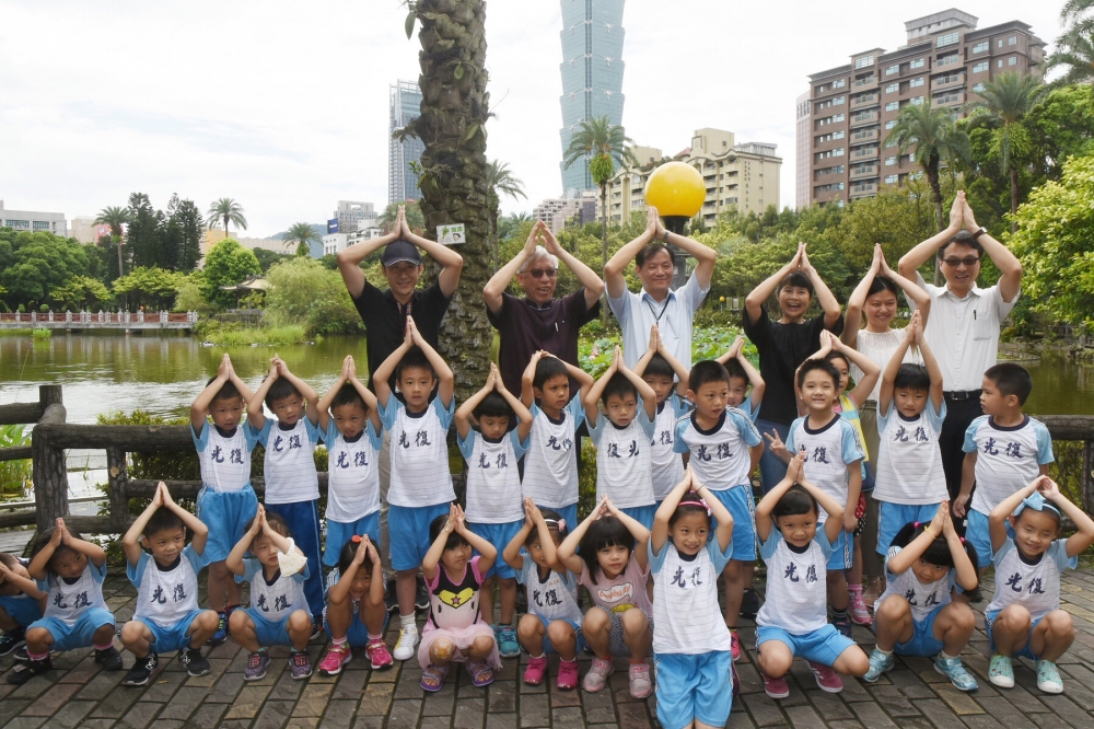 國館館長梁永斐帶著小朋友進行生態之旅，一起用手比出紅冠水雞的模樣。國父紀念館/提供