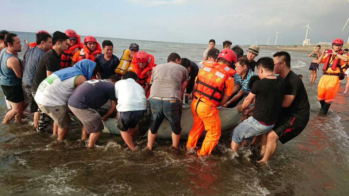 現場民眾與海巡共20人合力將重達700公斤的鯨豚搬上岸。第八岸巡隊/提供