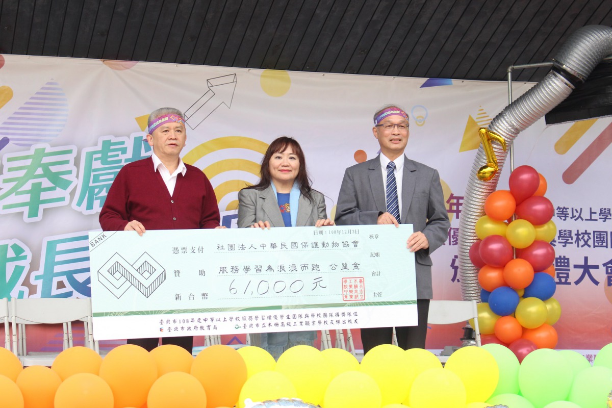 台北市教育局副局長洪哲義(左)與木柵高工校長李通傑(右)一同代表捐款給中華民國保護動物協會。 姚崇仁/攝