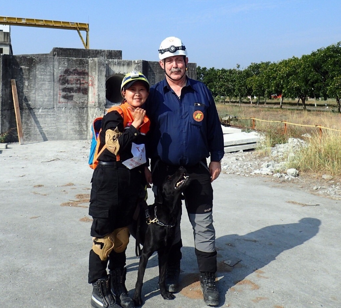 台東縣消防局領犬員魯雯霖率領搜救犬「山大」通過中級測驗。 台東縣政府/提供