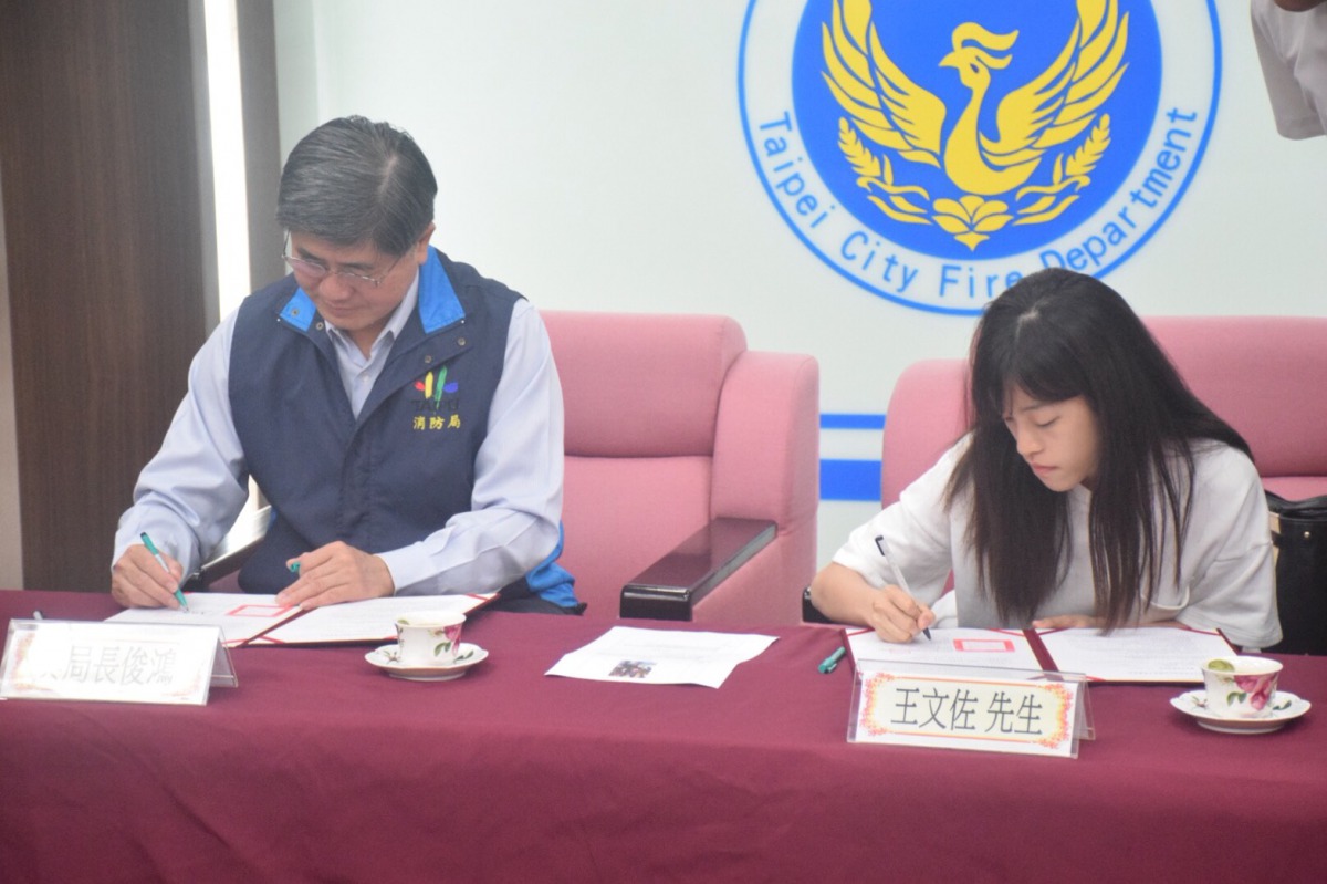 台北市消防局長吳俊鴻(左)與寄養人共同簽約。 姚崇仁/攝