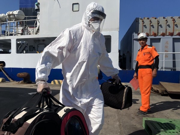 金門防疫人員將3袋裝有活體貓的提袋從船艙提上岸。海巡署金門岸巡隊/提供