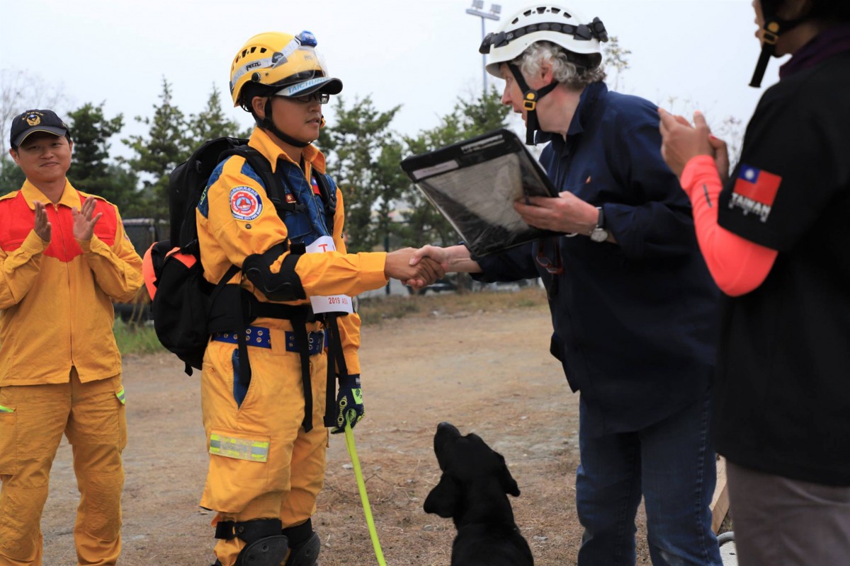 台中市消防局領犬員莊欣儒率領「腿腿」順利通過初級測驗。 取自/臺中GoGo - 狗狗 -臺中搜救犬粉絲頁