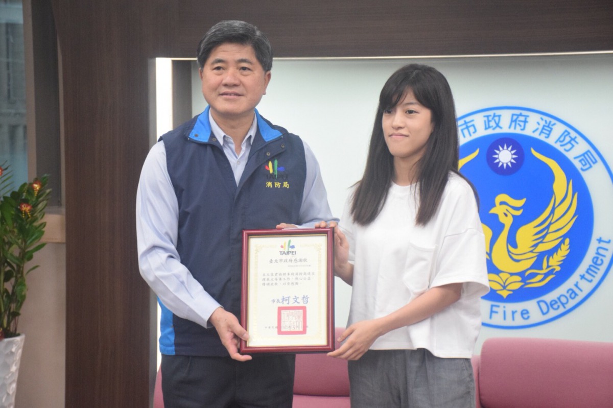 消防局長頒贈感謝狀給寄養人。 姚崇仁/攝