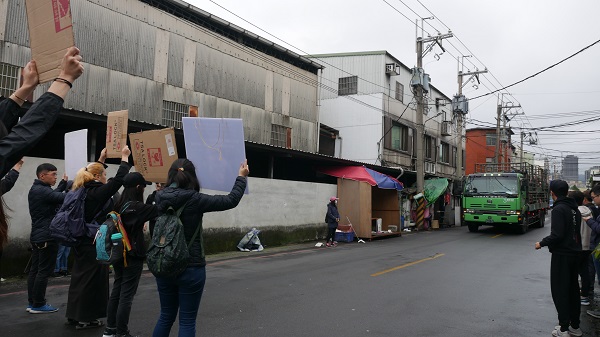 動物權推廣者在新北市肉品市場前,舉牌攔下送豬的貨車,希望與豬進行最後接觸。蔡育琳/攝